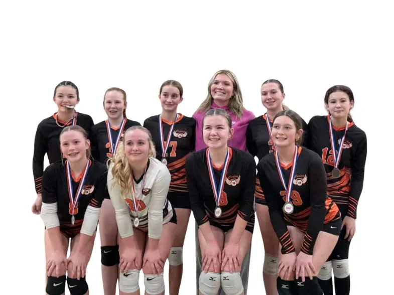Youth volleyball team in orange and black uniforms posing with their medals